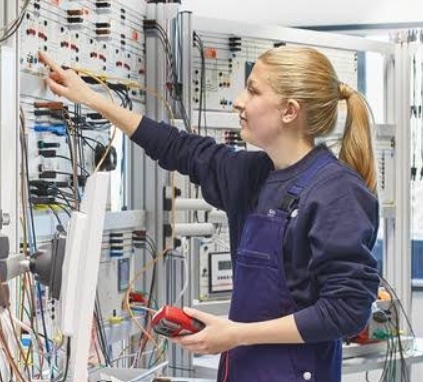 Trainee testing circuits on an electrical training board