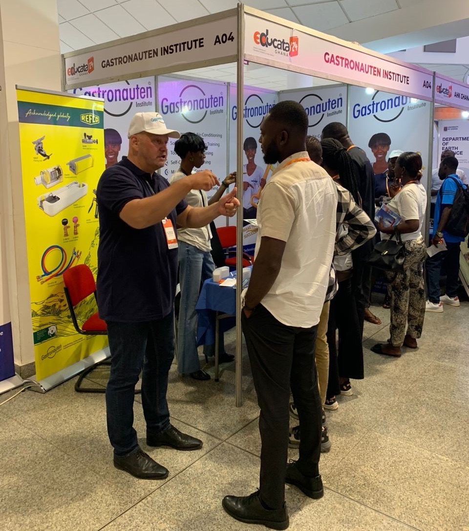 Instructor talking with a visitor at the Educata Ghana fair