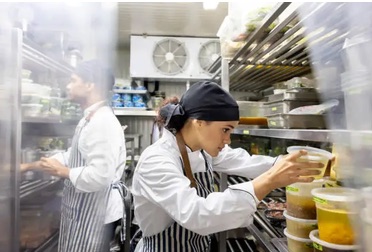 Kitchen staff storing food in the cold room