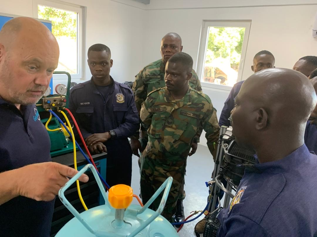 Instructor explaining a refrigerant cylinder and charging hoses