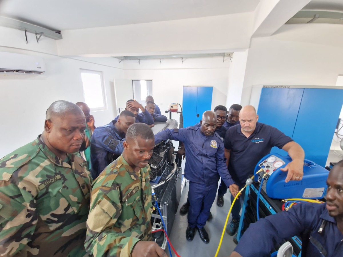 Instructor and trainees at the refrigerant recovery unit in the AC lab