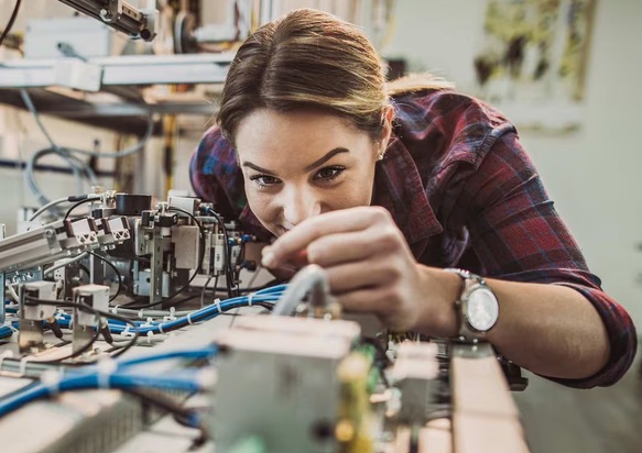 Trainee assembling wiring on a workshop training rig